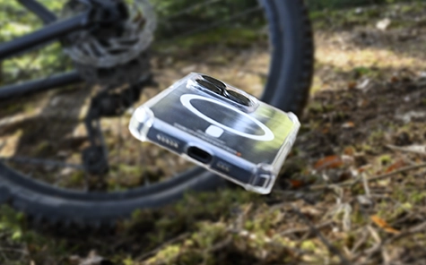 Smartphone-ul din husa telefonului mobil cade de pe bicicletă pe podeaua pădurii.