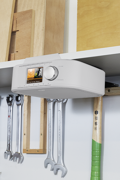 Digital radio mounted on a shelf in a workshop.